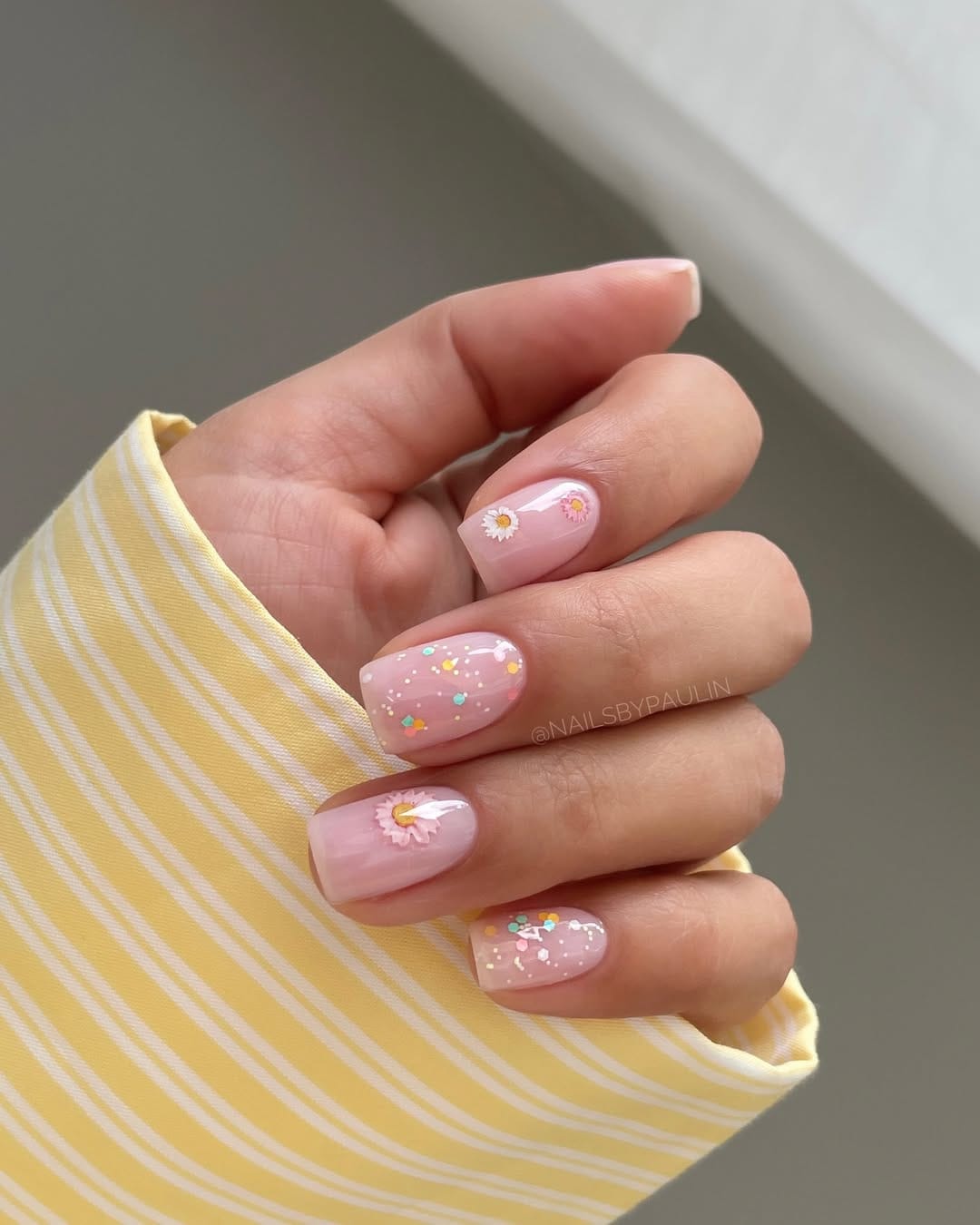 Blush pink daisy nails with confetti glitter accent for simple summer nails