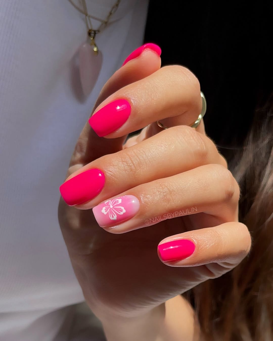 Neon pink nails with white hibiscus accent for a simple summer nail design