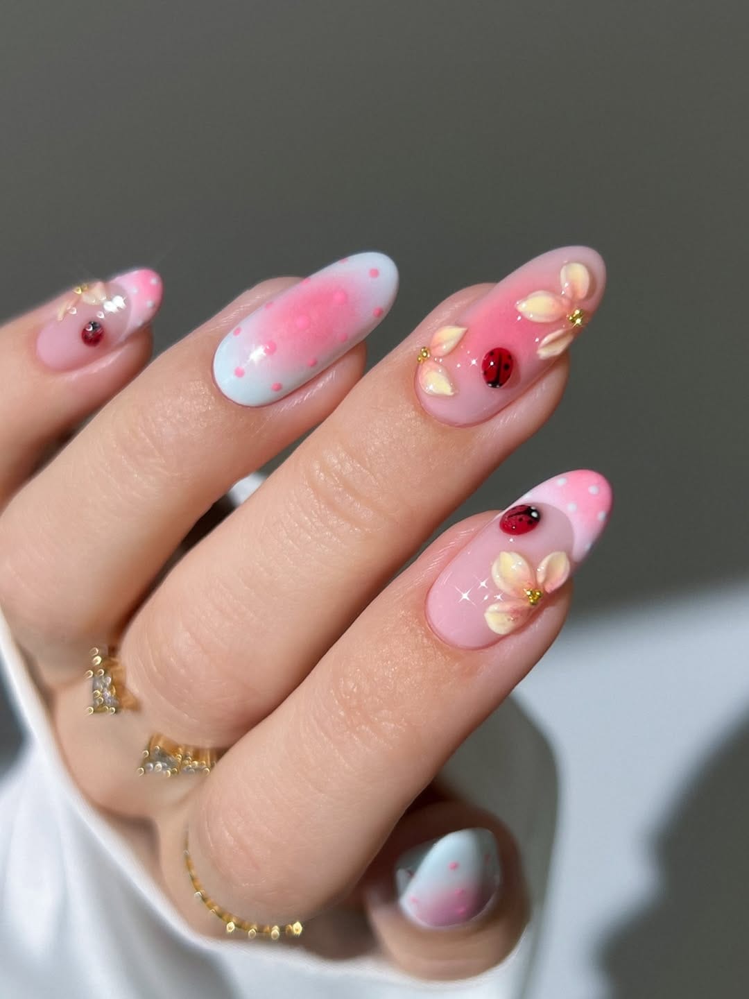 Pink ladybug and petal nail art for a cute simple summer nail idea