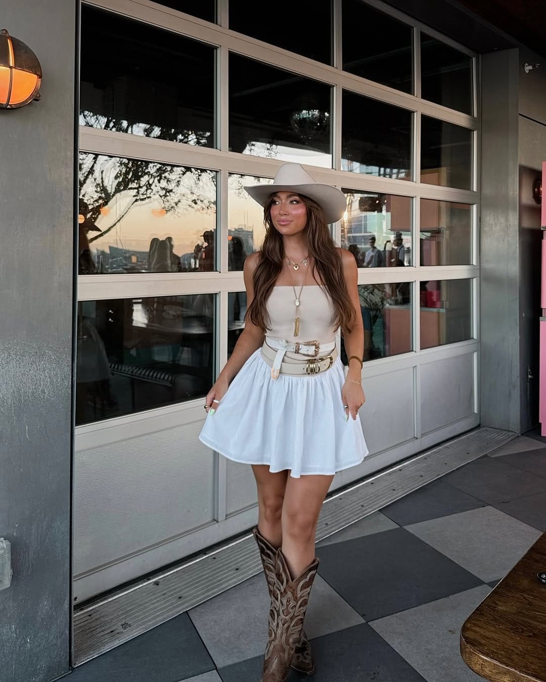 White mini skirt and tube top with double-buckle belt for a summer country concert outfit