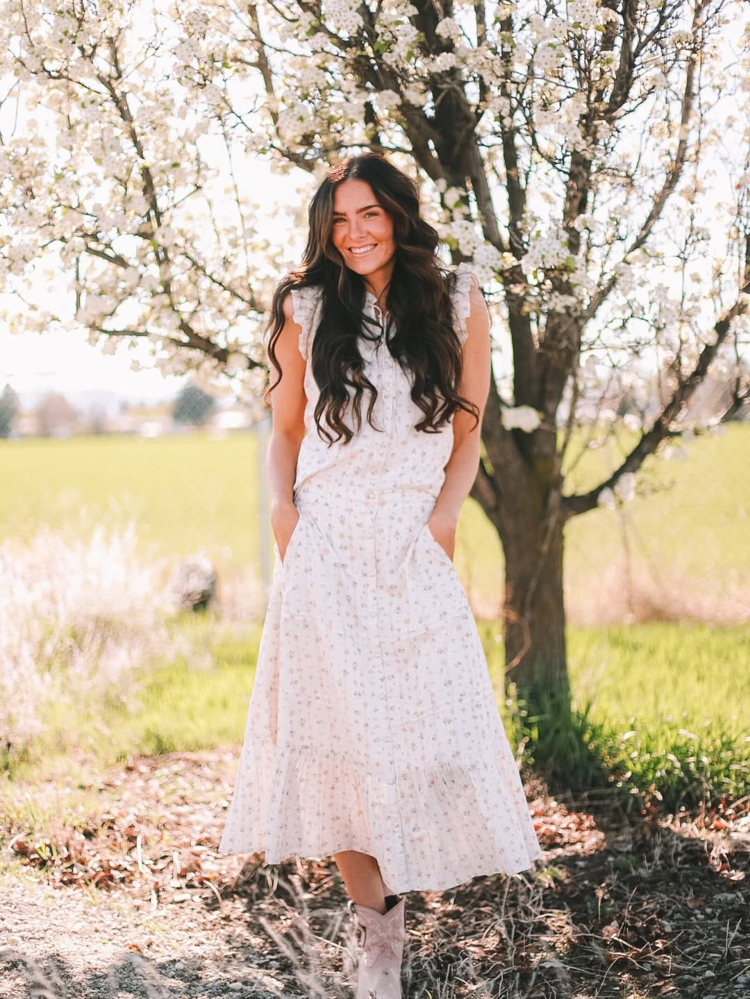 Cream and blush floral maxi dress with white cowboy boots for a country summer wedding guest outfit