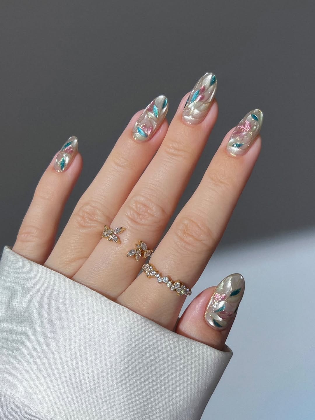 Pearl aurora nails with pink and teal petal brushstrokes for june nails