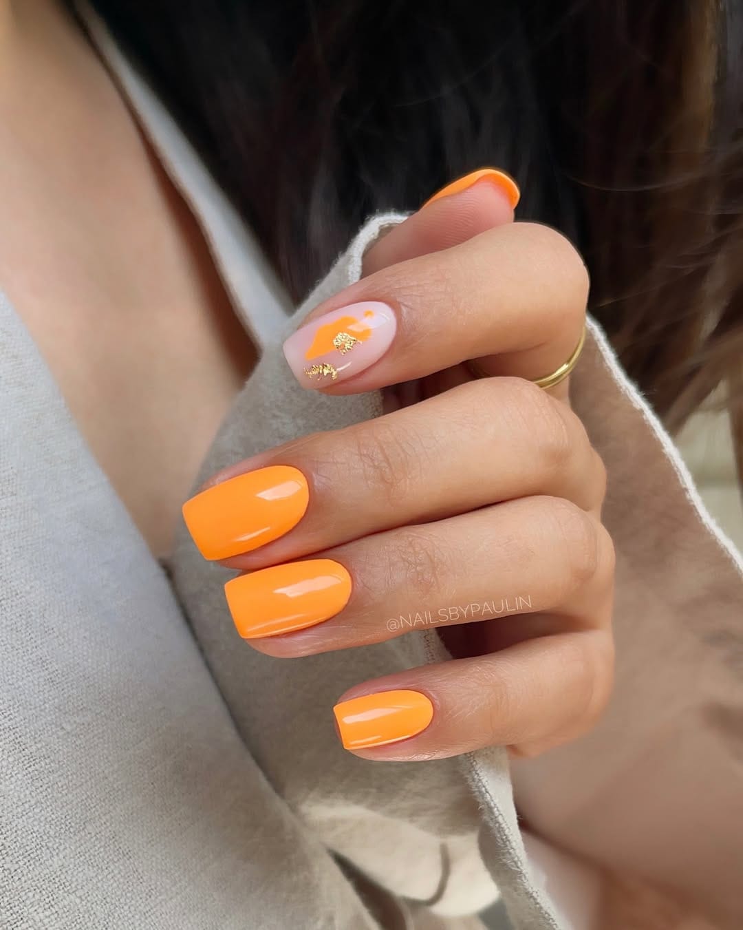 Neon orange nails with sheer gold foil accent for a bold june nail idea