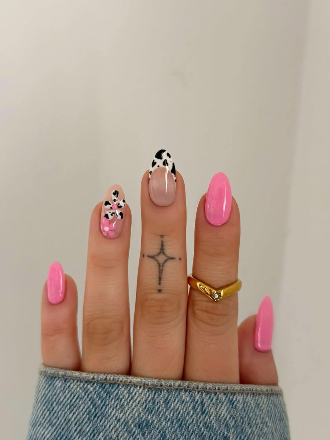 Bubblegum pink nails with cow print floral accent for a june nail design