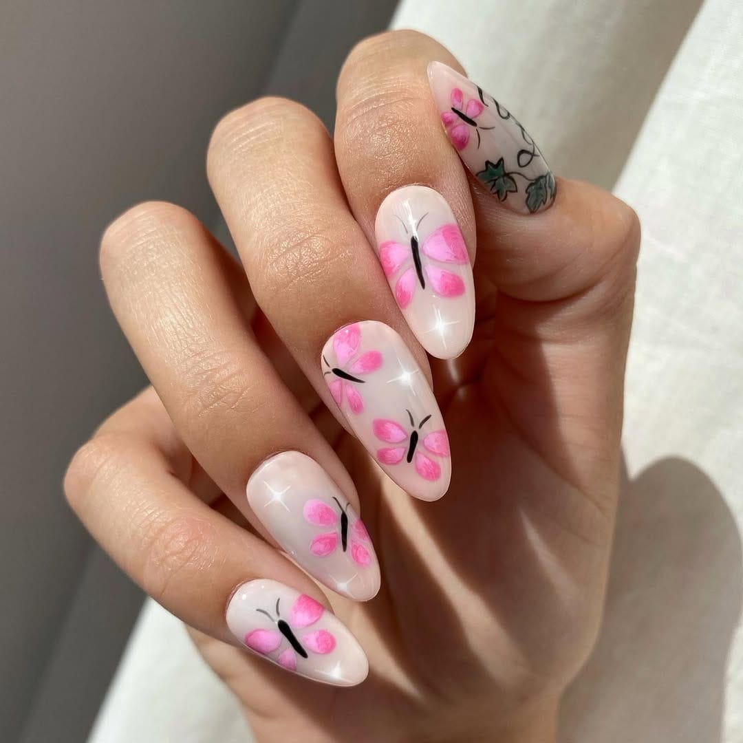 Sheer pink butterfly nail art on long almond nails for a june nail idea