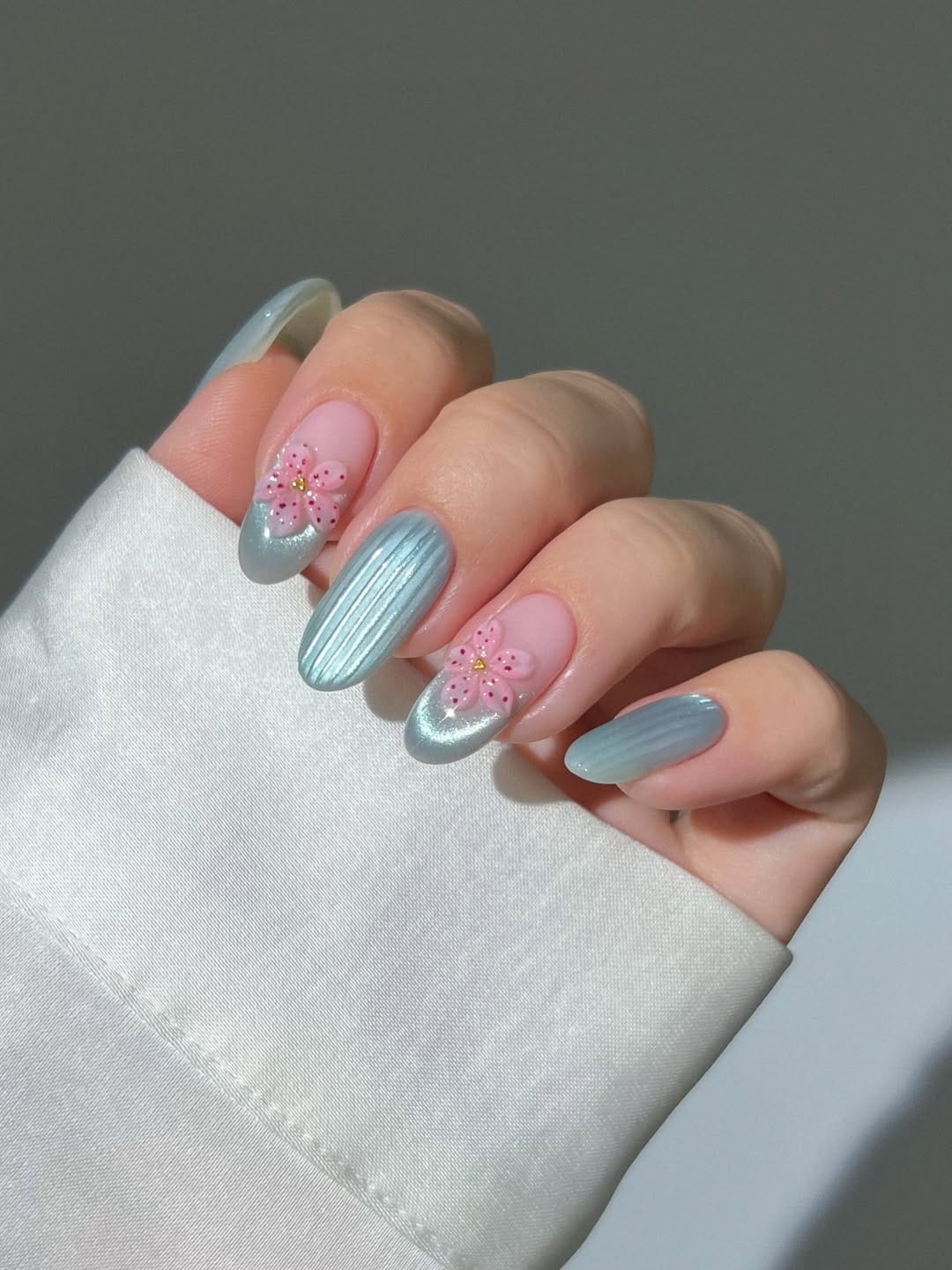 Silver chrome nails with cherry blossom accent for a june nail design