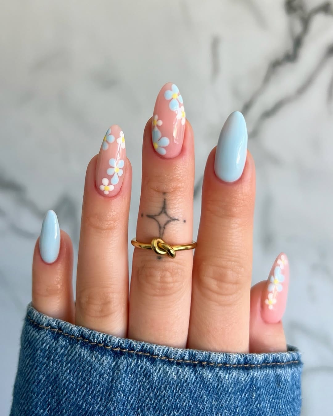 Baby blue daisy nail art on almond nails for a fresh nail trend 2026