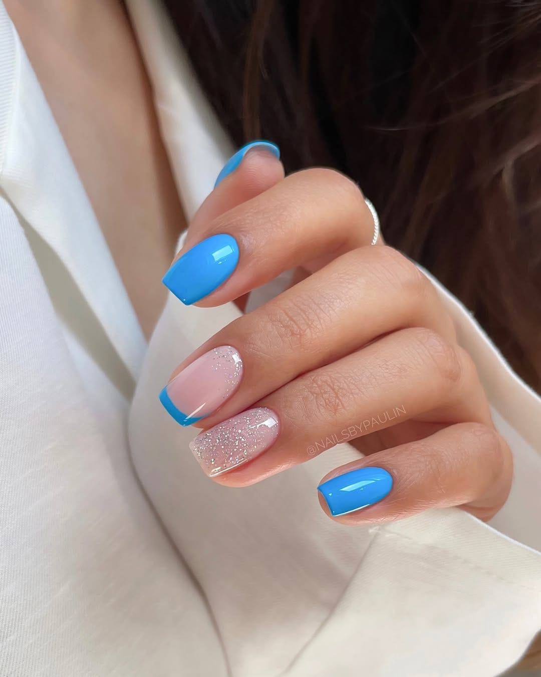 Cobalt blue French tip nails with glitter accent for a bold nail trend 2026