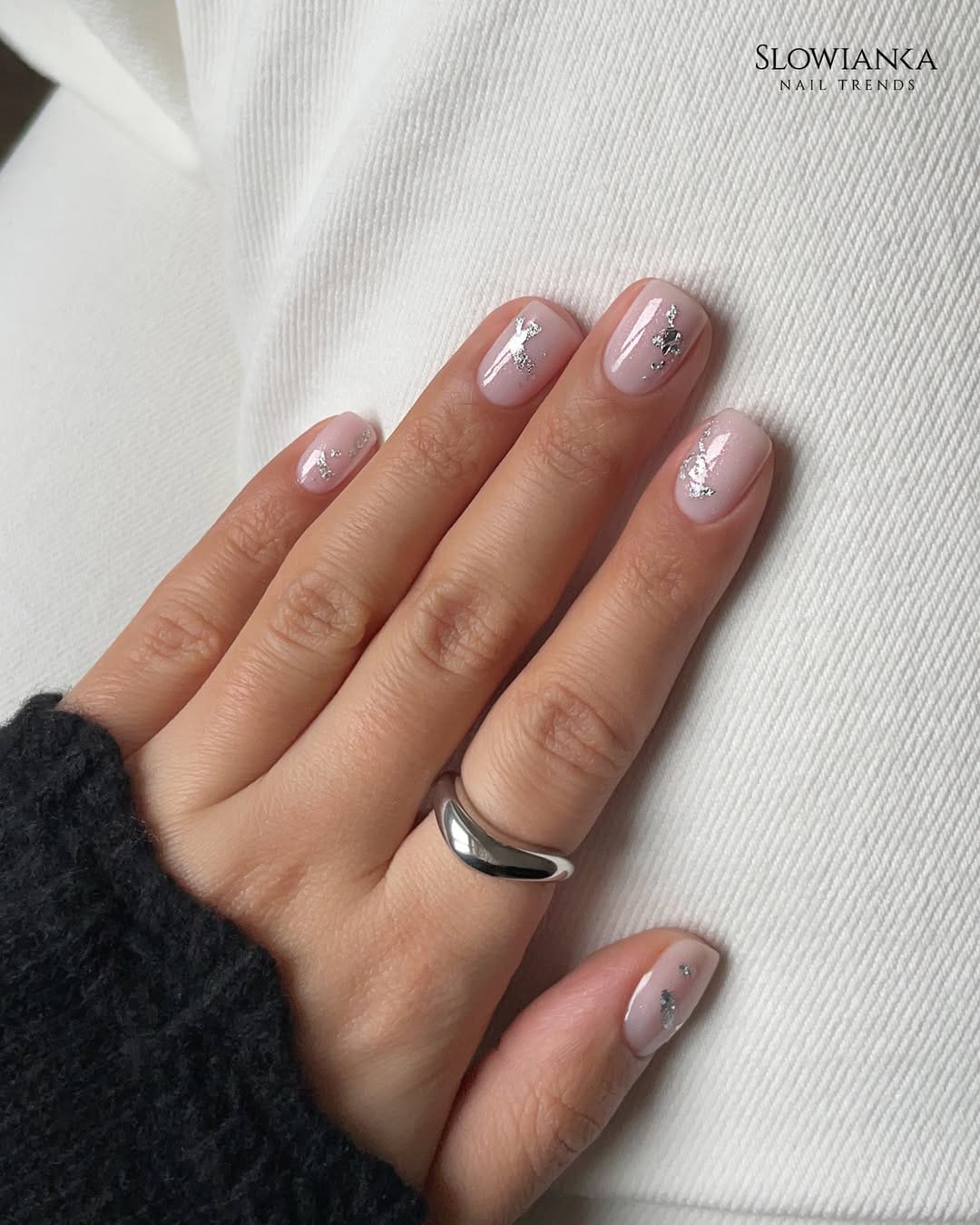 Sheer nude nails with silver foil fleck detail for a minimal nail trend 2026