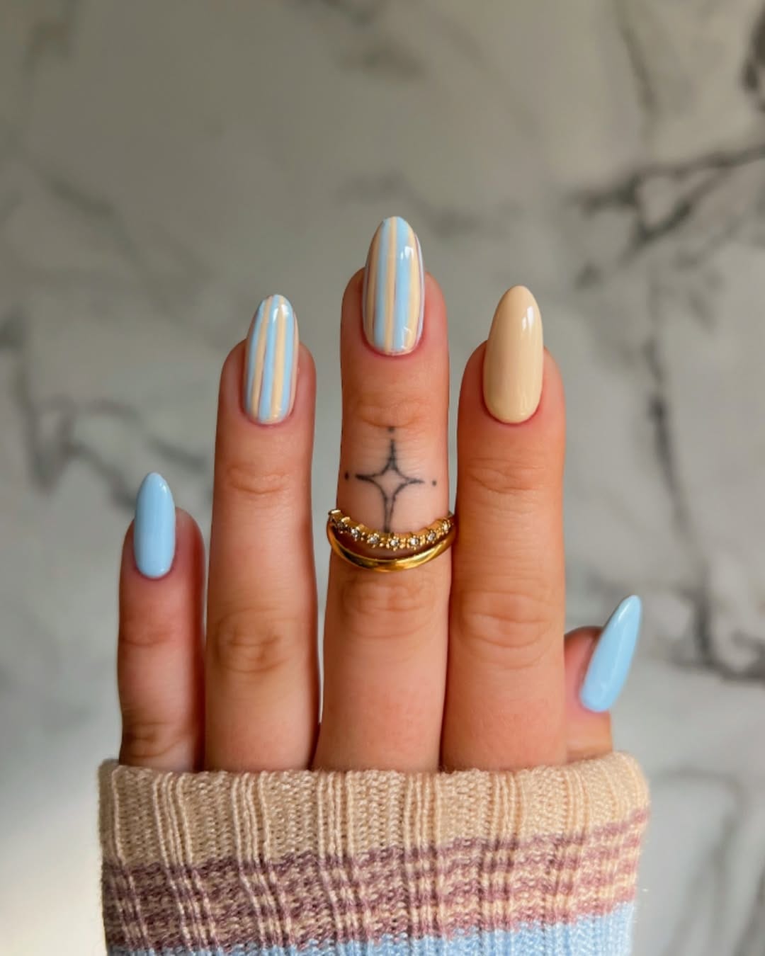 Baby blue and sand stripe almond nails for a minimalist nail trend 2026