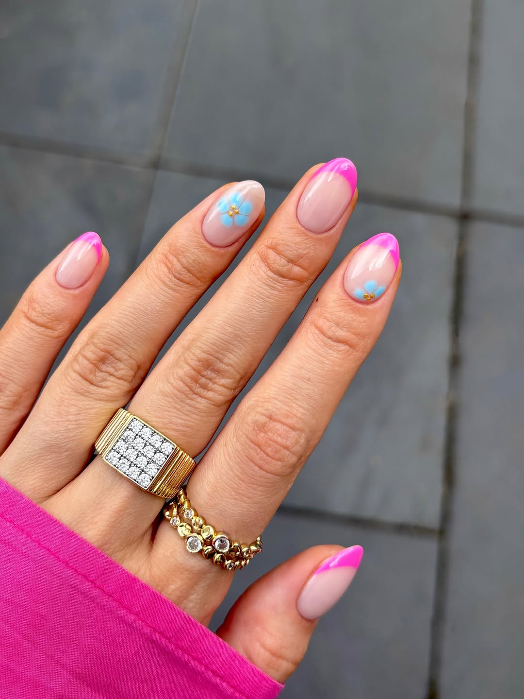 Short hot pink slanted French nails with tiny forget-me-not flowers