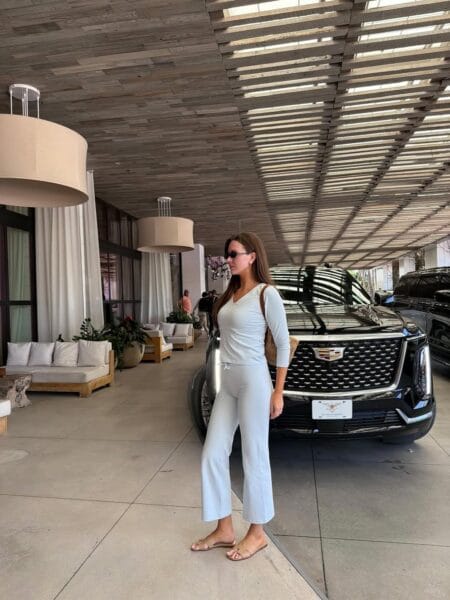 Woman in a pale blue ribbed knit top and matching wide-leg trousers with tan flat sandals