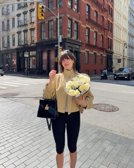 Camel ruffle blouse with black capri pants and structured handbag