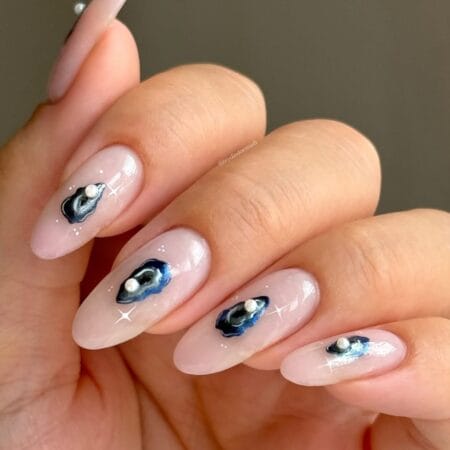 Almond nails with sheer blush base and hand-painted navy oyster shell with pearl bead on each nail — euro summer nails idea