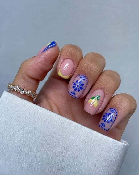 Short square nails with blue Majolica tile art, hand-painted lemon and cobalt yellow angular French tip — Amalfi Coast nail idea