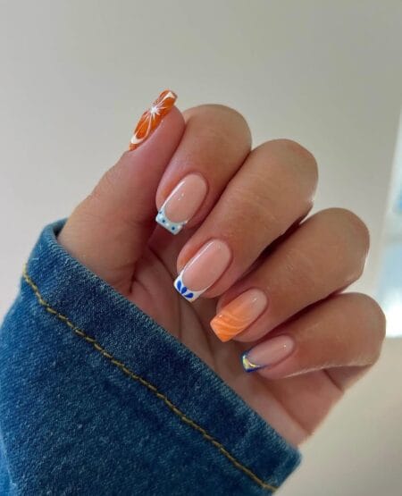 Short square nails with orange citrus slice thumb, blue dot-work French tips, orange swirl tip and cobalt micro French pinkie
