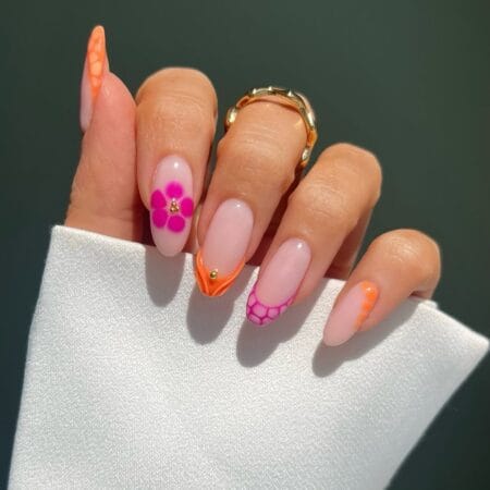 Nude almond nails with orange and hot pink retro floral French tips, honeycomb pattern and daisy motifs