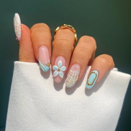 Almond nails with aqua swirl French tip, 3D white plumeria flower, wicker-print nail and gold oval accent — coastal nail idea
