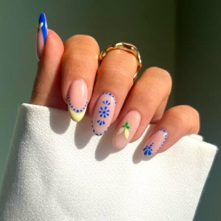 Almond nails with cobalt blue and butter yellow French tips, blue daisy dot-work and a hand-painted lemon — Mediterranean nail idea
