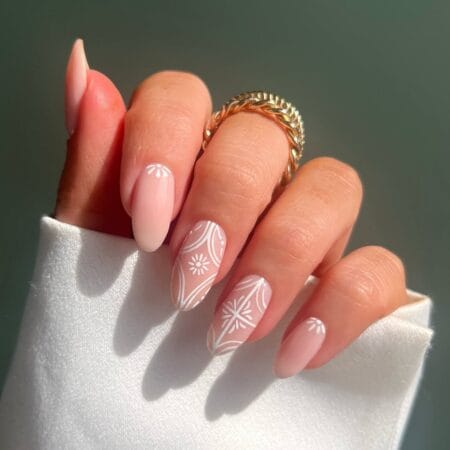 Blush pink almond nails with intricate white geometric lace and Moorish tile linework — euro summer nail design