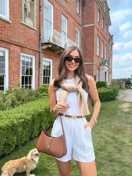 White ribbed tank with white tailored shorts and camel knit scarf July outfit