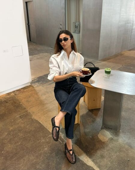 Oversized white shirt with dark indigo jeans and mesh flats July look