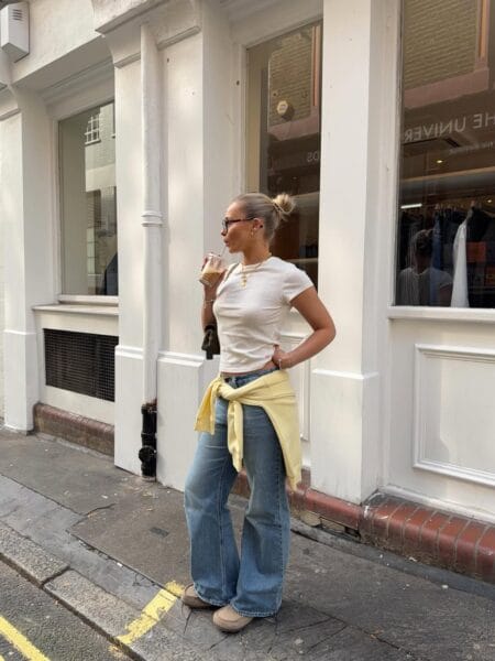 White ribbed baby tee and light-wash wide-leg jeans with butter yellow sweatshirt tied at the waist — june outfits 2026