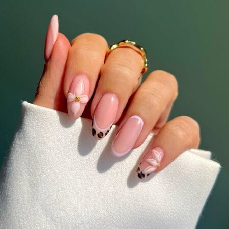 Blush French tip almond nails featuring 3D floral embellishments and leopard print details.