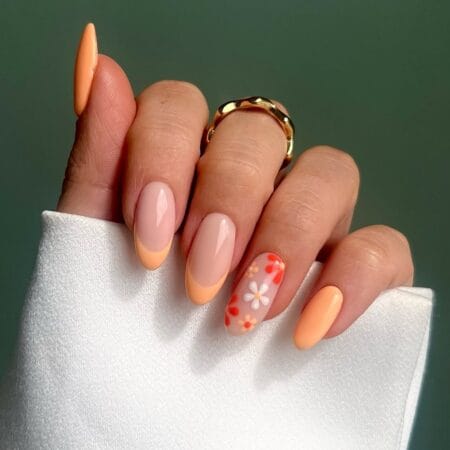 Peach French tip almond nails with retro daisy accent nail art.