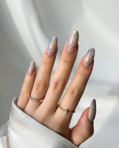 Smoky lavender marble almond nails accented with elegant gold leaf details.