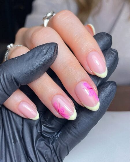 Lime yellow French tip almond nails with bold hot pink tropical flowers.