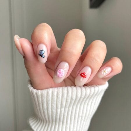 Cottagecore almond nails featuring soft pastel colors and whimsical floral details.