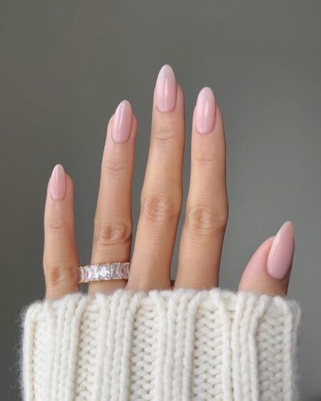 Solid pale pink almond nails with a glossy, minimalist finish.