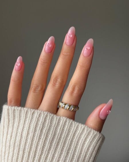 Pink ombré almond nails accented with tiny heart details.