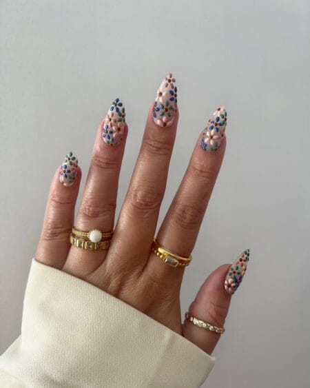 Multicolored almond nails decorated with cheerful ditsy daisy flowers.