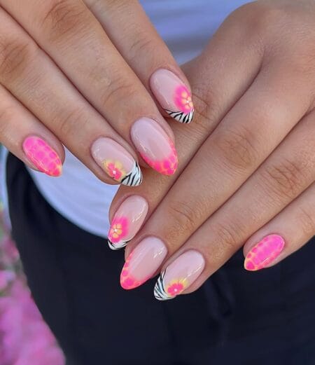 Neon pink French tip almond nails with zebra print and tropical flower details.