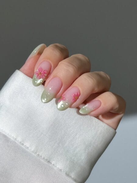 Almond nails with pearl French tips and delicate cherry blossom nail art.