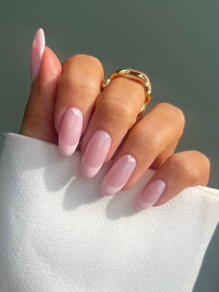 Glossy baby pink jelly almond nails with a translucent, glass-like appearance.