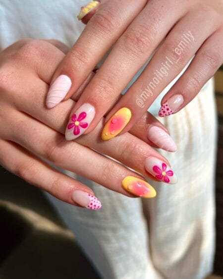 Pink and Yellow Mixed Aura Nails With Flower Art — medium almond nails mixing yellow to coral aura ovals, pink 3D flowers and polka dot tips on a milky base