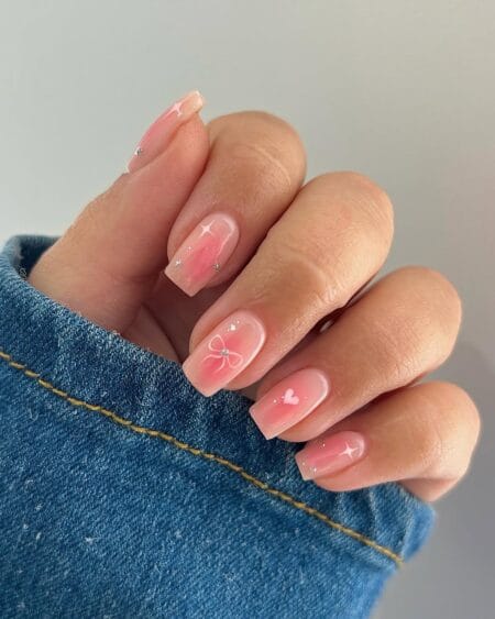 Pink Blush Aura Nails With Bow and Heart Details — short square nails with soft rose aura base featuring a painted bow, heart, star and rhinestone details