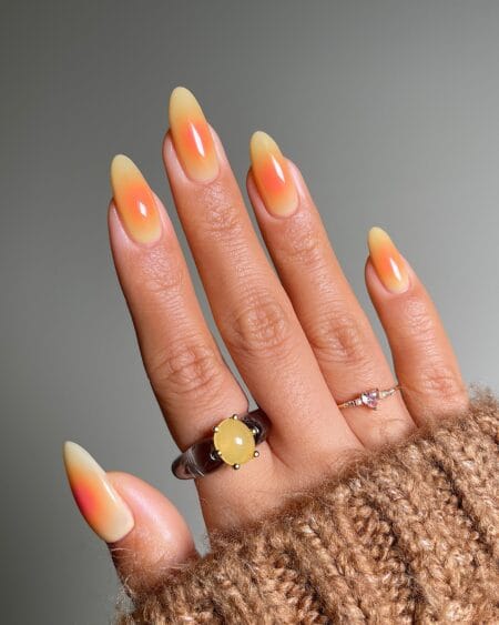 Sunset Orange and Yellow Aura Nails — long almond nails with butter yellow base melting into a vivid coral orange aura band at the centre