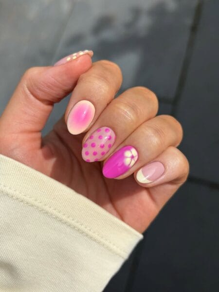 Mixed Technique Pink Aura Nails With Polka Dots and Flower — short oval nails mixing a hot pink aura bloom, polka dot nail, fuchsia flower detail and white tip French in one set