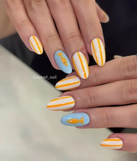 Medium almond nails combining white and marigold orange pinstripe nails with sky blue accent nails carrying a single golden fish — golden fish and orange stripe nails 2026