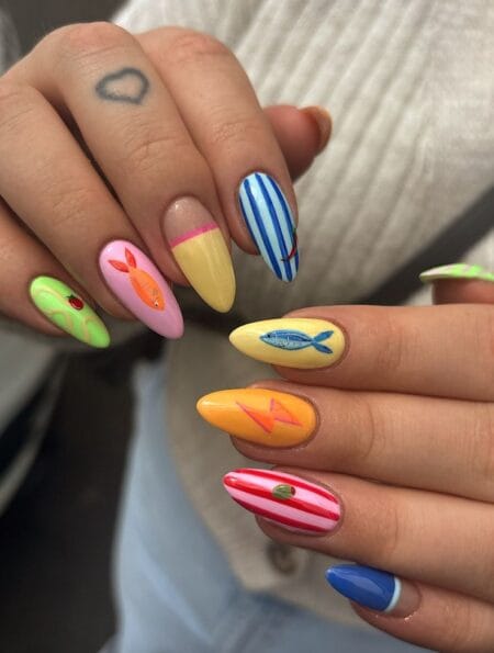 Long almond nails combining lime green strawberry nail, pink fish nail, blue white stripe nail with fishing line, yellow sardine nail and orange lure nail — coastal maximalist sardine and citrus nails 2026