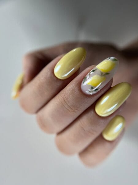 Lemon yellow oval nails with painted lemon and white blossom accent nail july nail idea