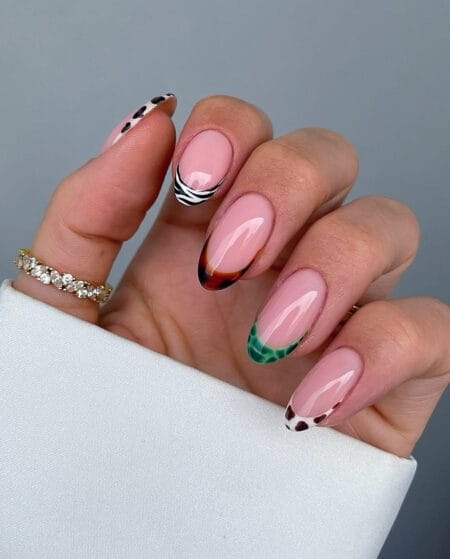 Multi-animal print French tip nails with zebra tortoiseshell snake and cow print on nude almond base