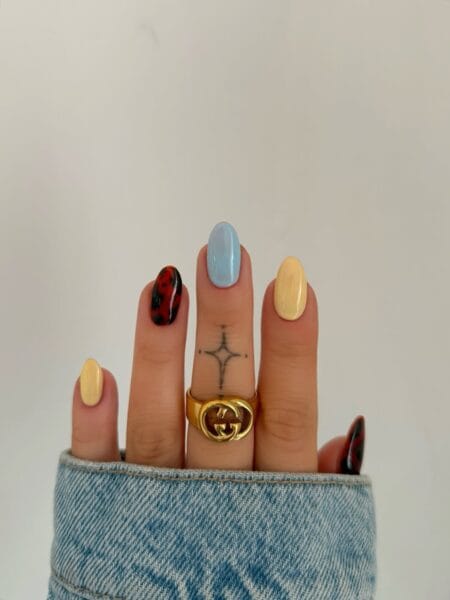 Butter yellow baby blue and tortoiseshell mix july nail designs on short rounded almond nails