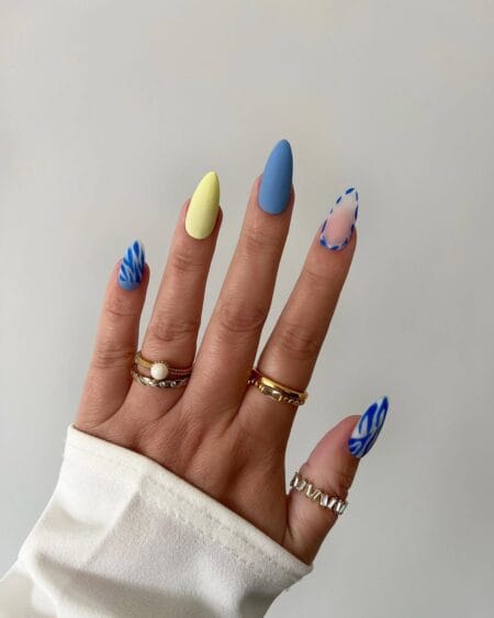 Cornflower blue matte and butter yellow almond nails with cobalt white wavy stripe accents