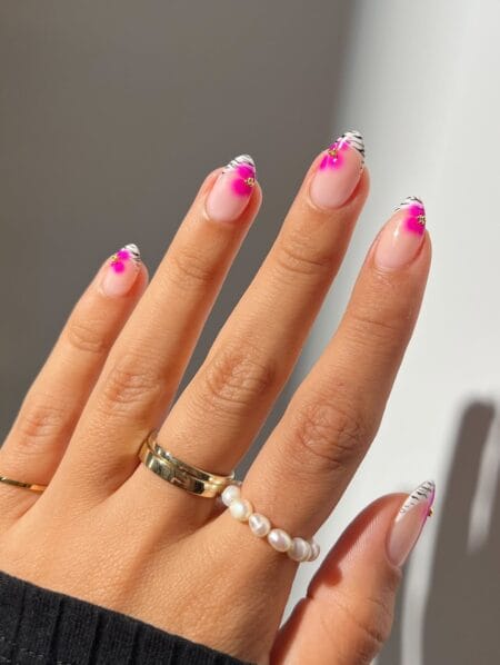 Zebra print and hot pink flower French tip almond nails with gold charm detail