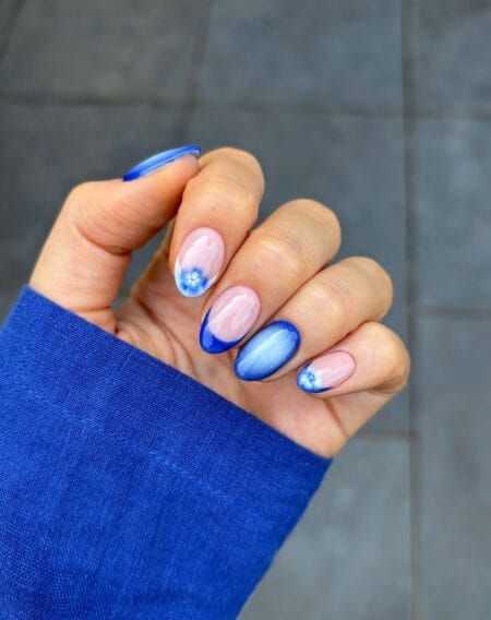 Klein blue aura oval nails with forget-me-not floral accents and royal blue French tips